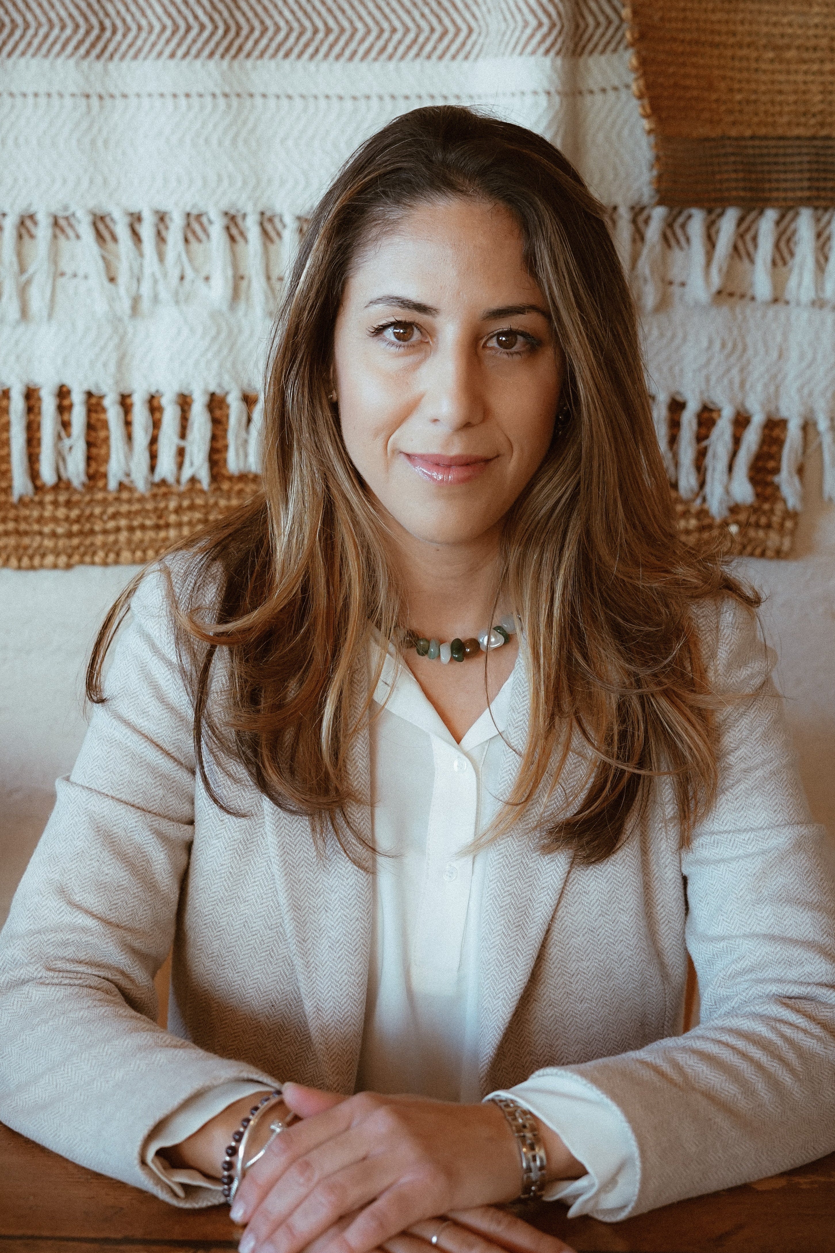Noelia, co-founder of Bold Womban, sitting on chair, light background
