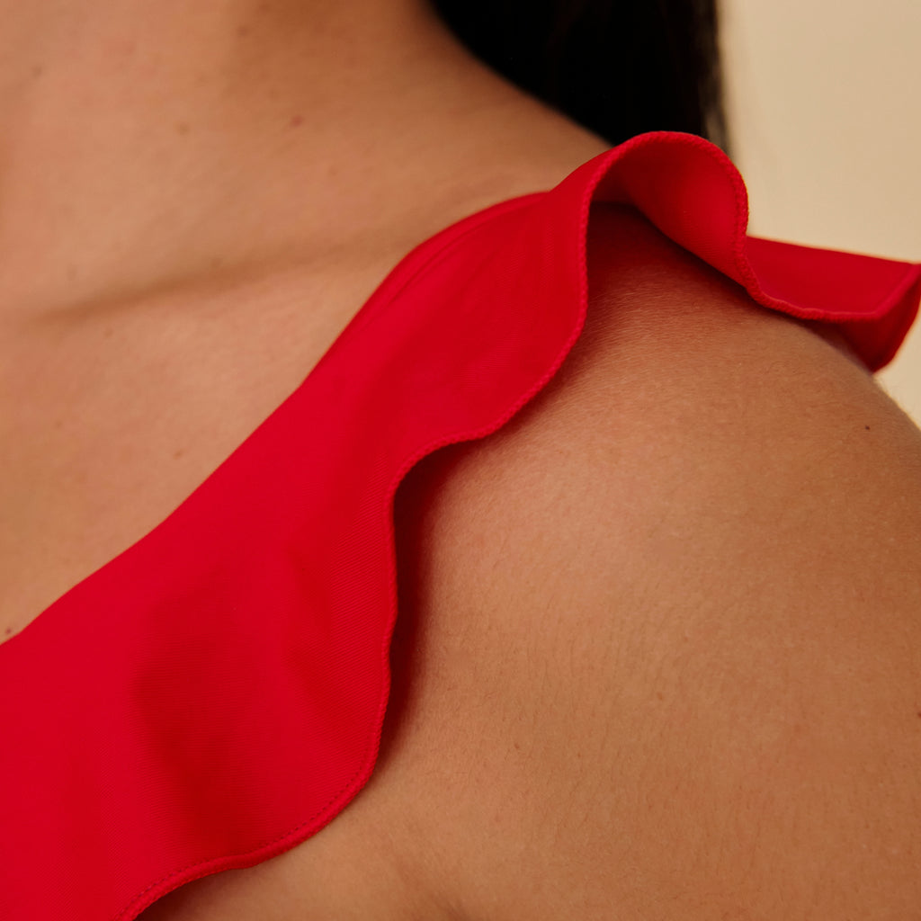 Close-up of a red swimsuit on a person's shoulder, made in Spain